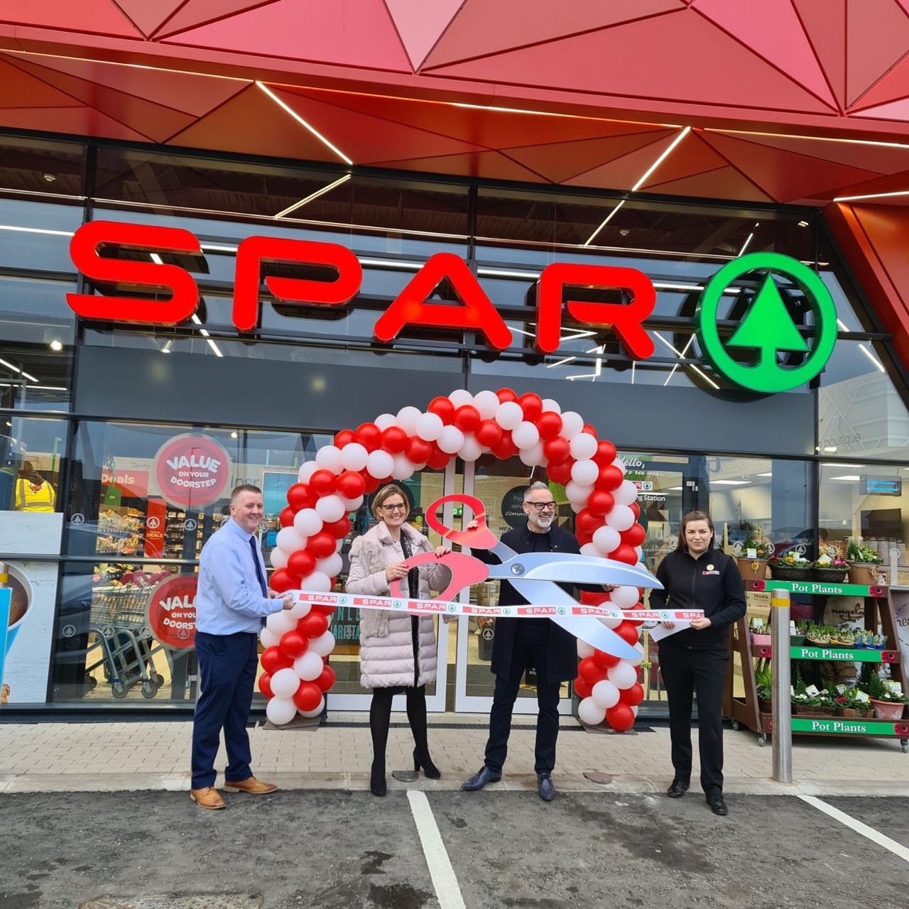 The Wall Group team at a store opening ribbon cutting